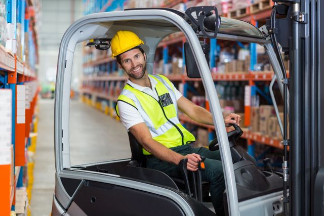 Warehouse worker operating forklift and smiling in busy storage area full of shelves and packaged goods, highlighting job safety and efficient logistics management. Perfect for use in industrial, logistics, and warehouse management promotional materials, safety training manuals, and articles on occupational safety and efficiency.