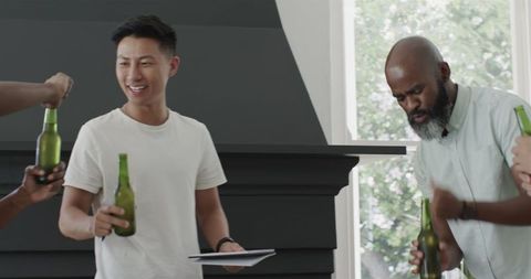 Friends Discussing Plans with Tablet and Drinks Indoors