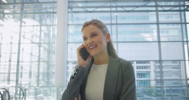 Confident Businesswoman Smiling During Phone Call in Modern Office - Download Free Stock Images Pikwizard.com