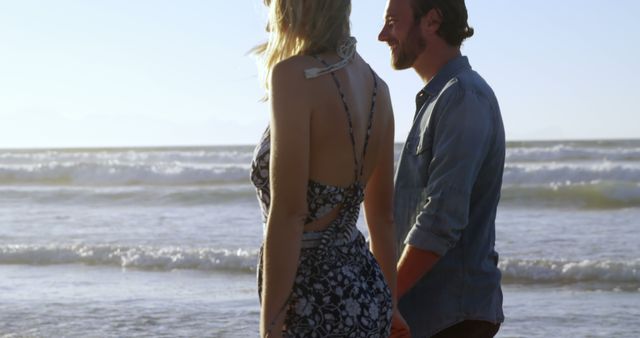 A couple shares a serene, romantic beach walk at sunset. - Download Free Stock Photos Pikwizard.com