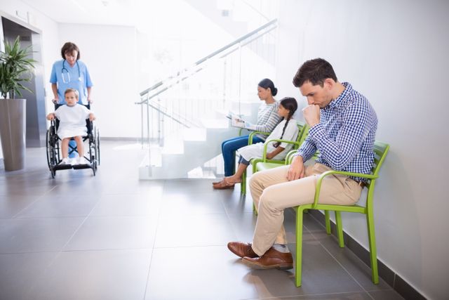 Thoughtful man sitting on chair in hospital corridor