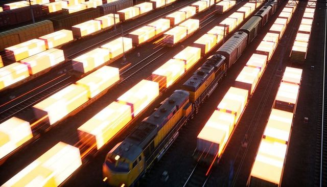 Moving yellow locomotives pulling glowing container trains with light streaks at dusk