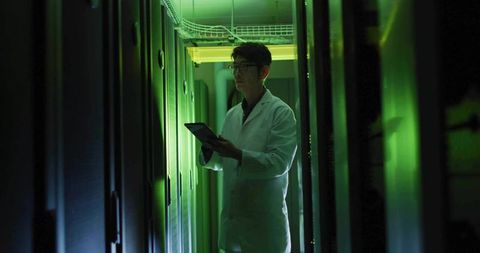 Korean Technician Inspecting Server Room with Green Lights