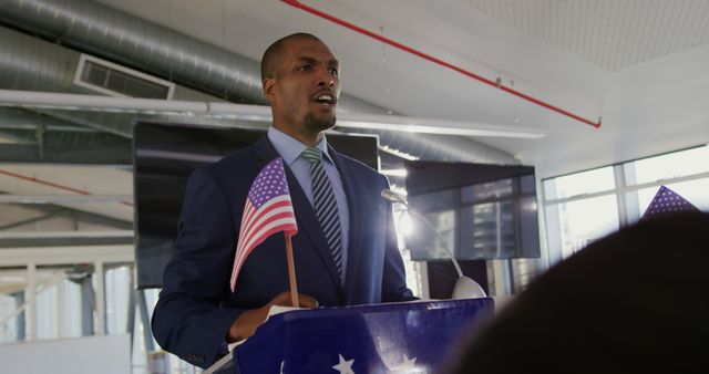 African American businessman giving speech with American flags in modern office - Download Free Stock Images Pikwizard.com
