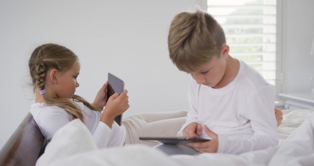 Kids Using Tablets while Sitting on a Bed in Well-Lit Room - Download Free Stock Images Pikwizard.com