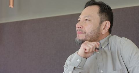 Middle-Aged Asian Professional Contemplating Ideas in Modern Office