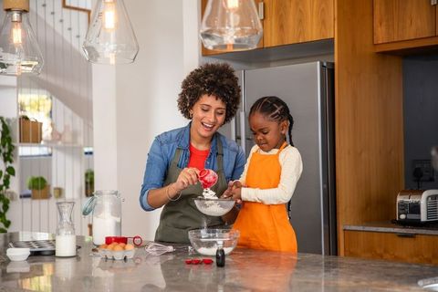 Mother and Daughter Joyfully Baking Together Pairing Flour in Modern Kitchen