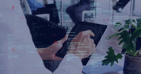 Holding tablet in corporate meeting with code overlay showing team collaboration