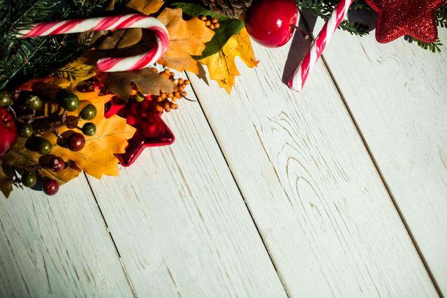 Christmas Decorations on Wooden Plank with Autumn Leaves and Candy Canes - Download Free Stock Photos Pikwizard.com