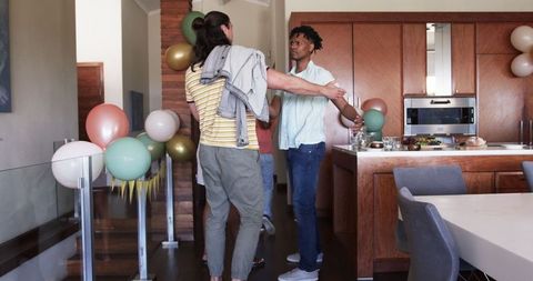 Friends Celebrating in Modern Kitchen with Festive Decorations