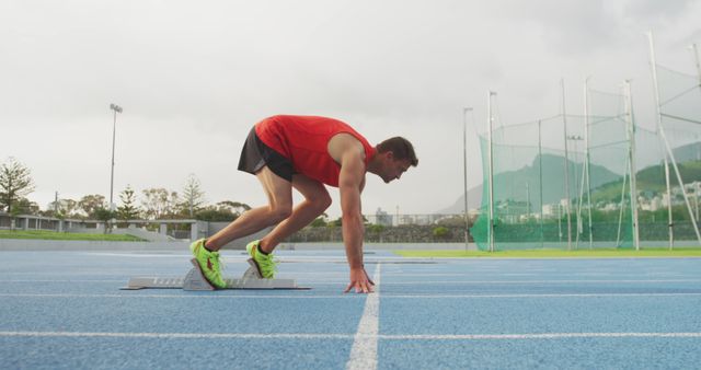 Young Male Sprinter in Starting Position on Outdoor Track - Download Free Stock Images Pikwizard.com