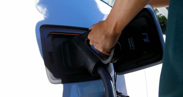 Caucasian woman charging electric car with copy space - Download Free Stock Photos Pikwizard.com