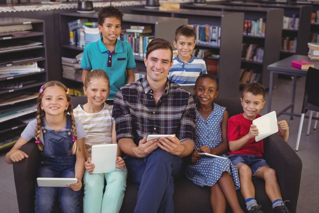Happy Teacher with Diverse Schoolkids Using Tablets in Library - Download Free Stock Photos Pikwizard.com