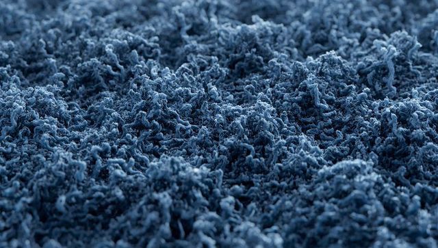 Revealing blue shag carpet macro texture with twisted yarn pile and plush tufted fibers