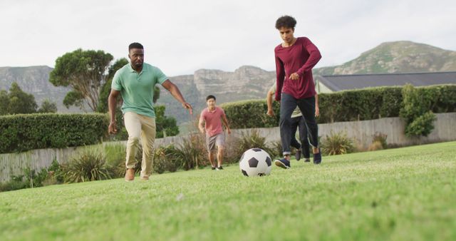 Happy diverse male friends playing football in garden on sunny day - Download Free Stock Photos Pikwizard.com