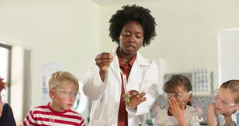 African american science teacher leading hands-on lab with elementary students