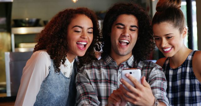 Friends Laughing While Looking at Smartphone in Cafe - Download Free Stock Images Pikwizard.com