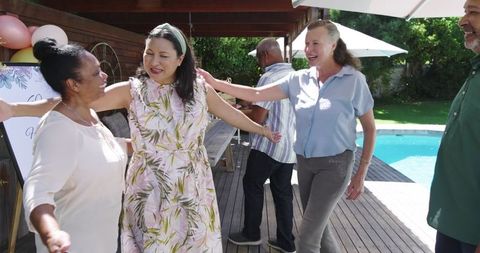 Seniors celebrating in garden by poolside festive gathering