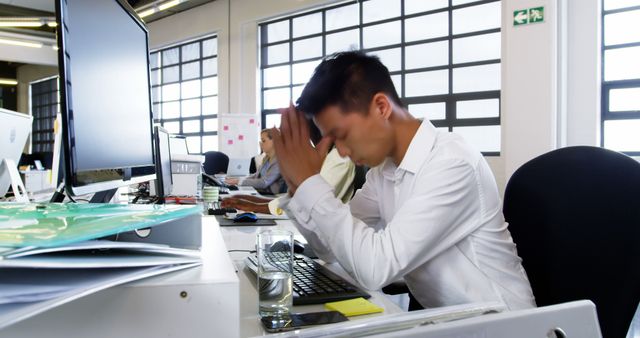 Stressed Businessman Working at Modern Office Desk with Computers - Download Free Stock Images Pikwizard.com