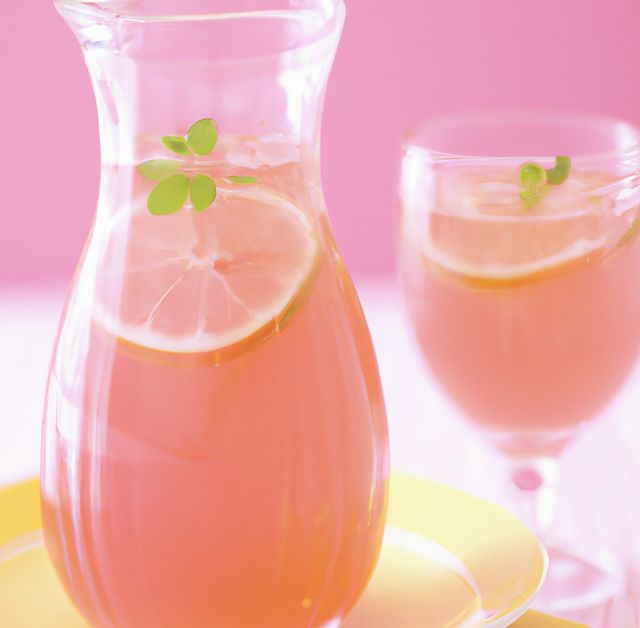 Close up of pink lemonade on pink background created using generative ai technology. Drink, flavour and food concept, digitally generated image.