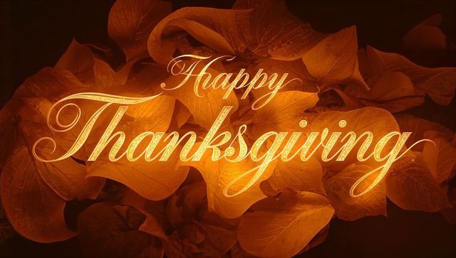 Happy thanksgiving gold calligraphy over glowing autumn leaves elegant holiday typography