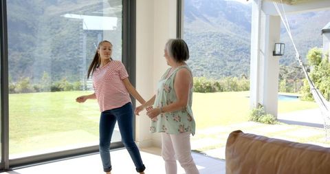 Granddaughter and Grandmother Dancing and Enjoying Time at Home