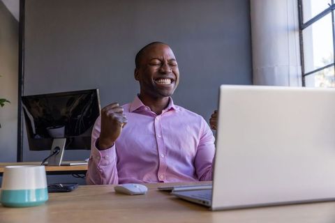 Excited Businessman Celebrating Success at Work Desk