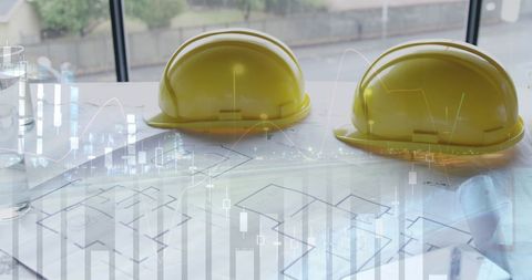 Safety helmets on construction blueprints with digital overlay