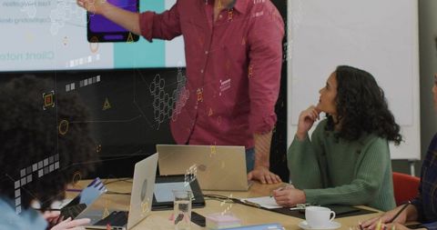 Presenting Team Collaborating in Meeting Room with Laptops and Digital Data Overlays