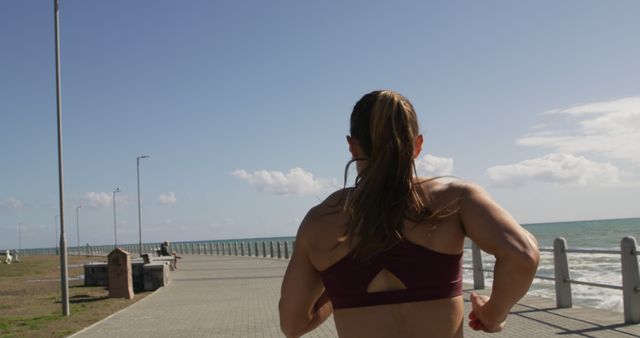 Young woman exercising on beachfront promenade at dawn - Download Free Stock Images Pikwizard.com