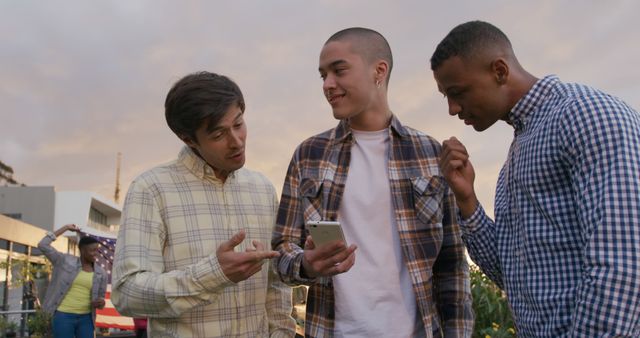 Friends Socializing and Viewing Smartphone in Urban Park - Download Free Stock Images Pikwizard.com