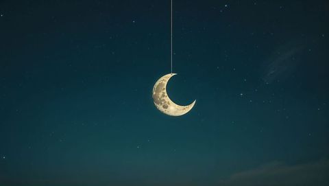 Crescent Moon Hanging in Star-Filled Night Sky