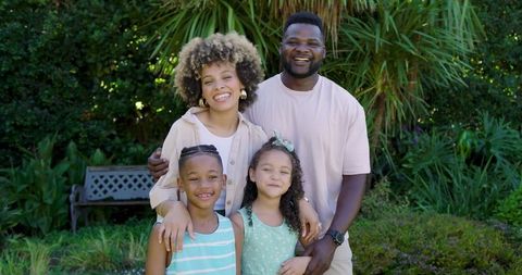 Happy african american family enjoying time in lush backyard garden