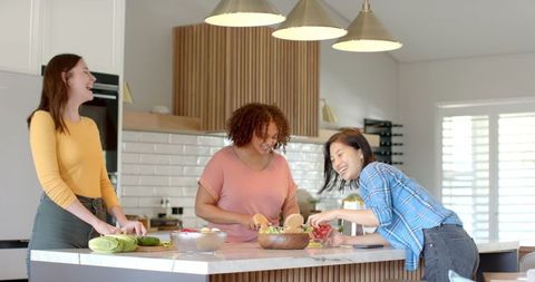 Diverse Friends Enjoy Cooking and Smiling in Bright Kitchen