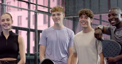 Diverse friends enjoying padel on modern indoor court