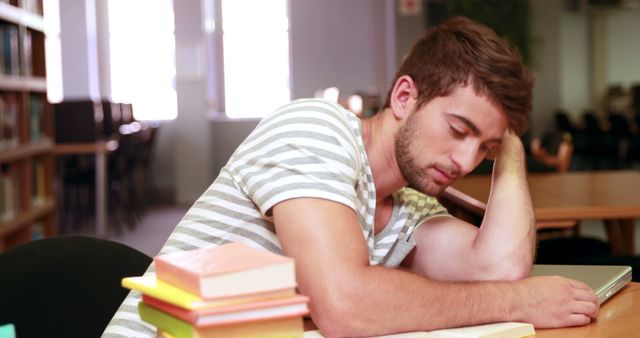 Exhausted Student Resting Head on Desk in Library - Download Free Stock Images Pikwizard.com