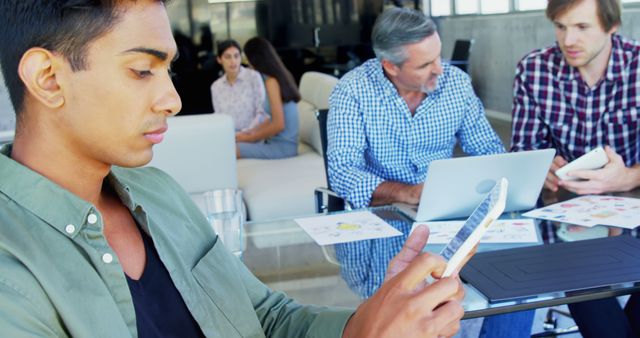 Young Businessman Using Smartphone during Office Meeting - Download Free Stock Images Pikwizard.com