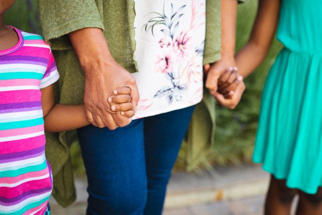 Midsection of african american girls holding african american mature grandmother's hands. unaltered, family, lifestyle, childhood and leisure activity.