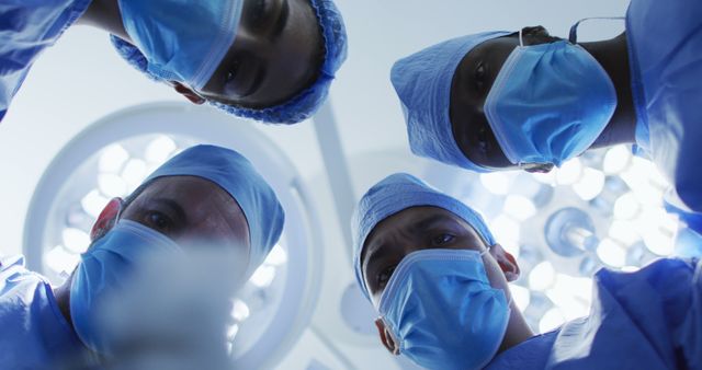 Medical professionals operating on patient, captured from patient's perspective looking up at surgeons, provides realistic view for depicting medical procedures, health care settings, and teamwork dynamics in advertising or educational materials related to health care and surgery.