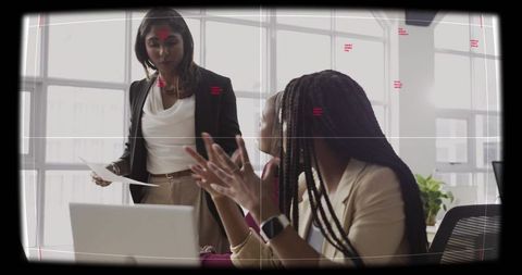 Female leaders presenting and collaborating in modern office meeting with laptop