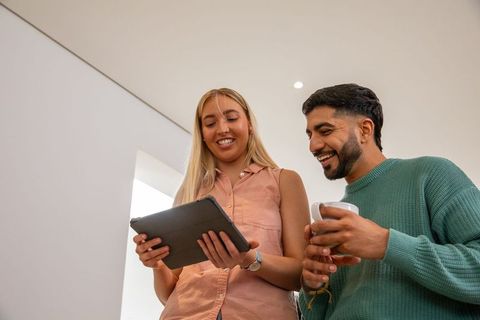 Friends engaging with digital tech while socializing at home