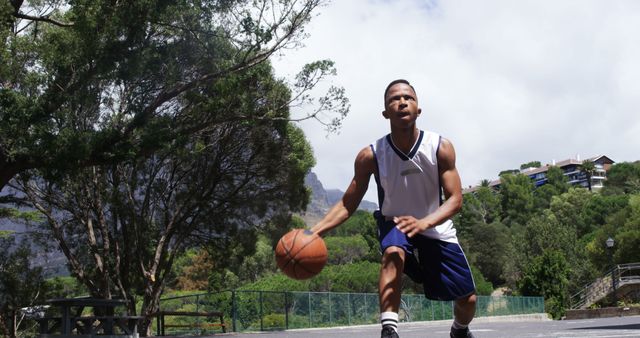 Young Athlete Dribbling Basketball Outdoors in Park - Download Free Stock Images Pikwizard.com