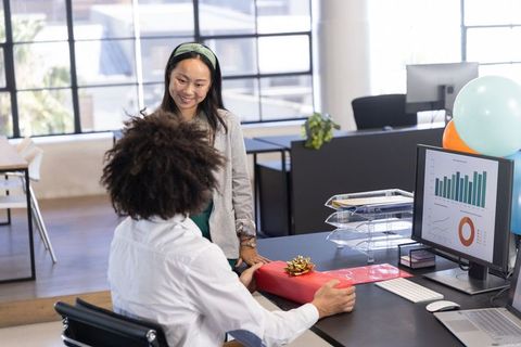 Colleagues Exchanging Gift in Modern Office Environment