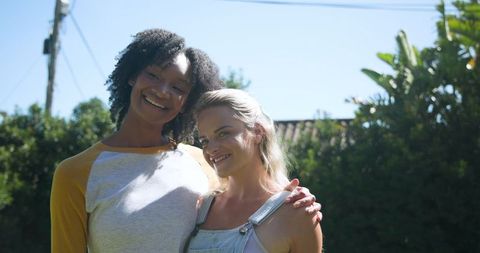 Diverse Female Friends Embracing in Sunlit Backyard