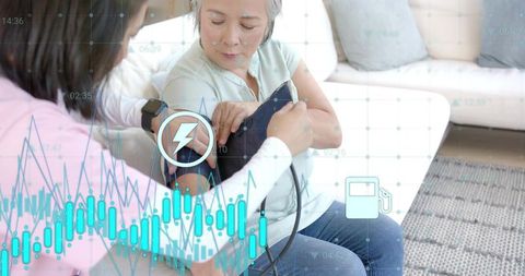 Caregiver adjusting blood pressure cuff on senior asian woman with smart health overlays