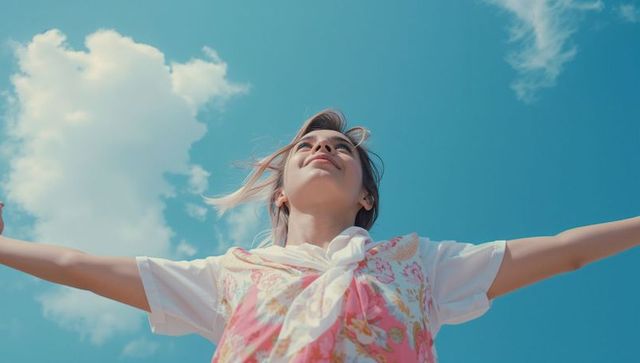 Carefree Woman Embracing Freedom Under Clear Blue Sky