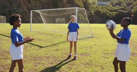 Diverse Girls Playing Soccer Outdoors on Grass Field
