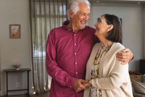 Senior couple embracing in cozy living room showing affection