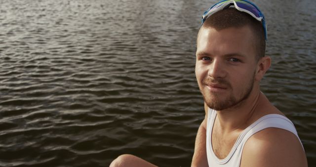 Young Man Sitting by Lake in Sunglasses Enjoying Outdoors - Download Free Stock Images Pikwizard.com