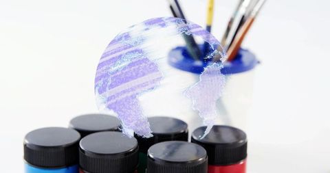 Holographic Globe Floating Above Paint Jars and Brushes Creative Art Concept